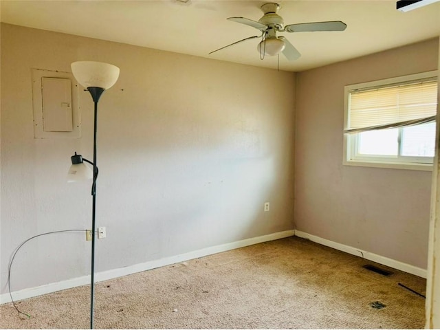 spare room with carpet floors, electric panel, and ceiling fan