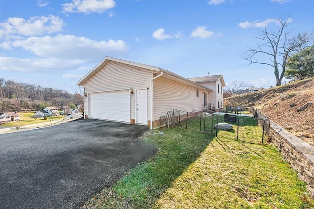 view of side of property with a garage and a lawn