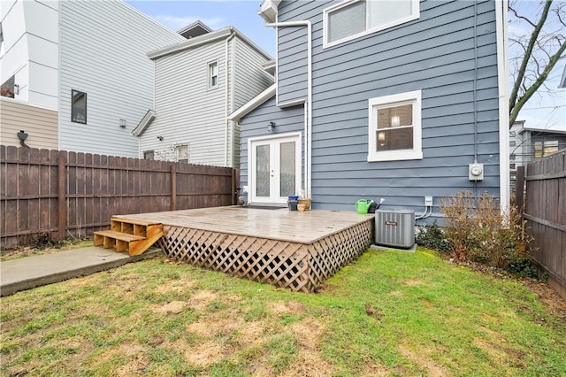 rear view of property featuring central AC unit, a yard, french doors, and a deck