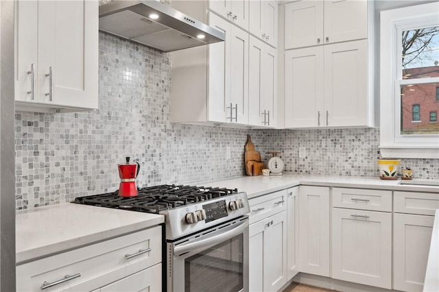 kitchen featuring white cabinetry, extractor fan, backsplash, and stainless steel range with gas stovetop