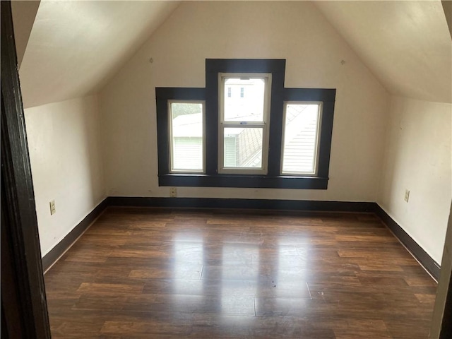 additional living space with dark wood-type flooring and lofted ceiling