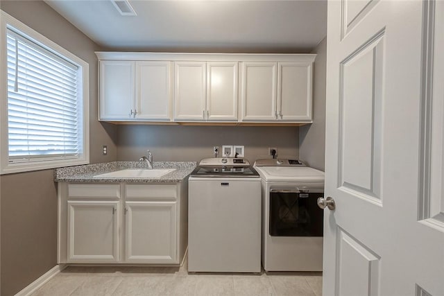 clothes washing area with sink, light tile patterned floors, cabinets, and washing machine and clothes dryer