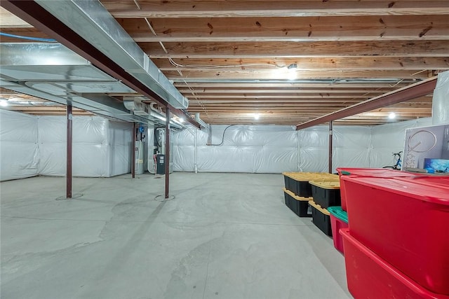 basement featuring heating unit and electric water heater