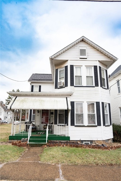 view of front of home with cooling unit, a porch, and a front lawn