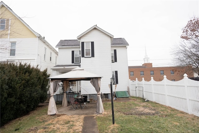 back of property with a gazebo, a yard, and a patio