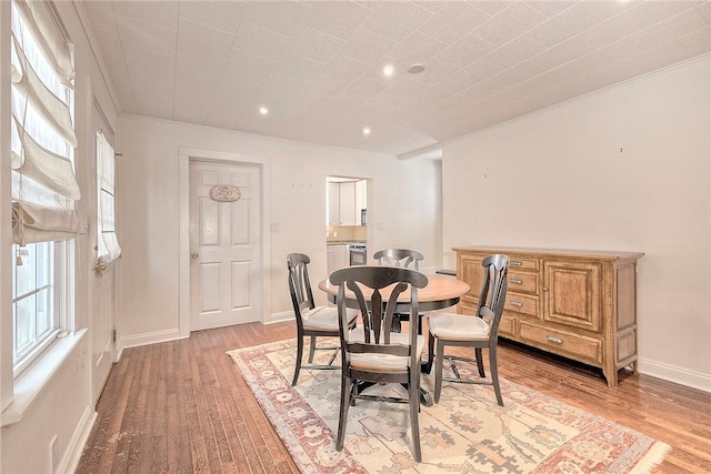 dining space featuring crown molding and hardwood / wood-style floors