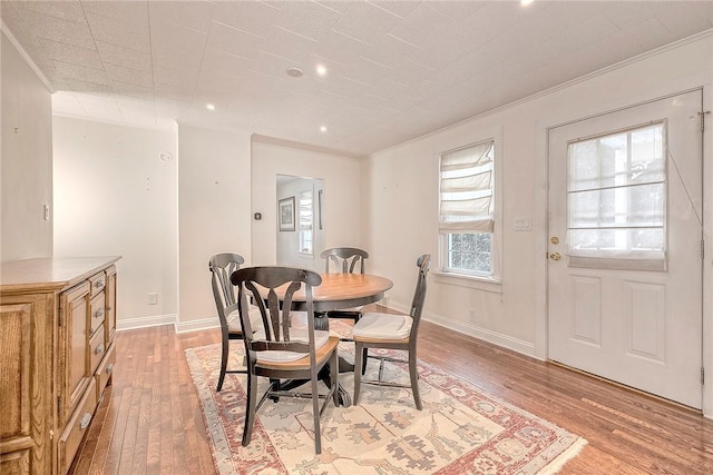 dining area featuring crown molding and light hardwood / wood-style flooring