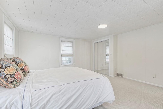 bedroom with light colored carpet and a closet