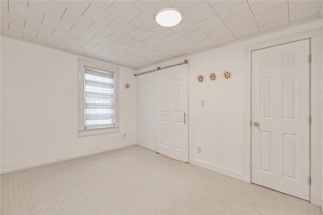 empty room with light colored carpet and a barn door