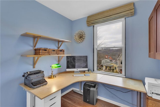 home office with built in desk and light wood-type flooring