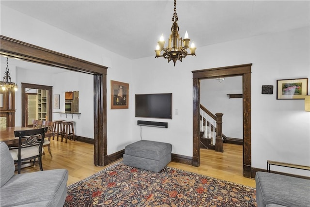 living room featuring an inviting chandelier and light wood-type flooring