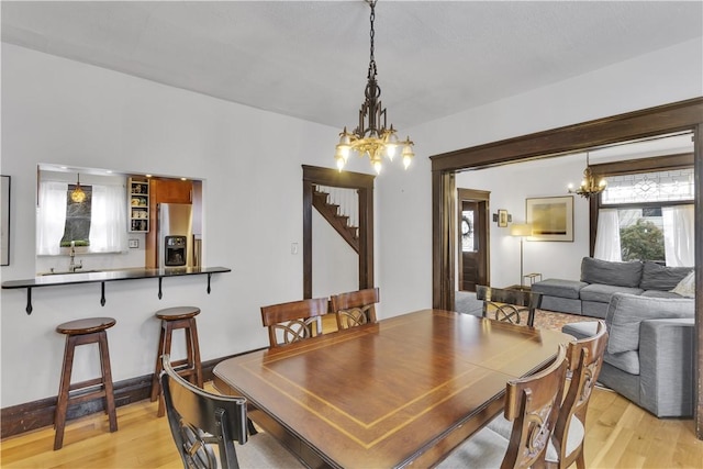 dining space with an inviting chandelier and light hardwood / wood-style floors