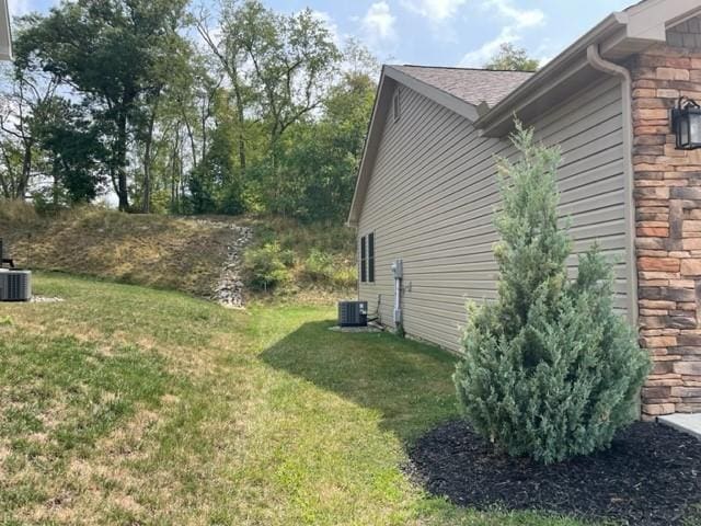 view of side of property with cooling unit and a lawn