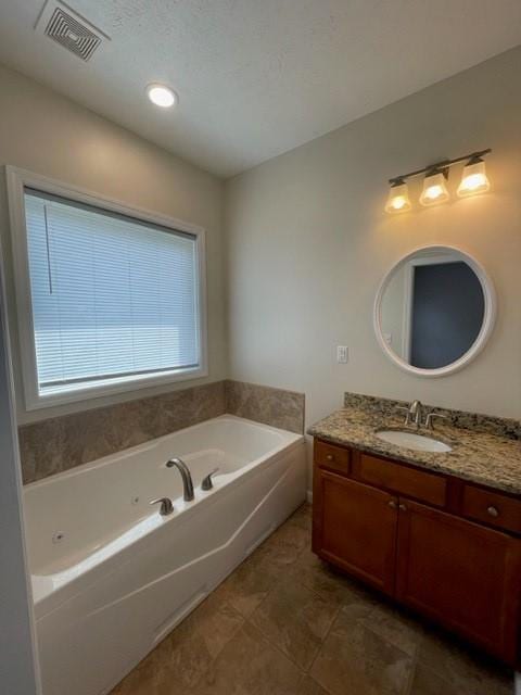 bathroom with vanity and a washtub