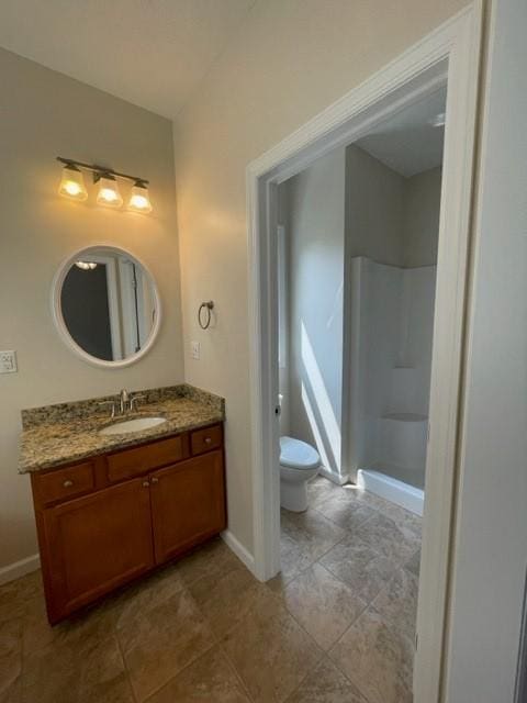 bathroom with walk in shower, vanity, and toilet