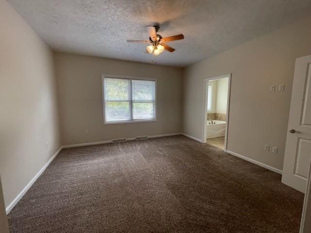 unfurnished room featuring ceiling fan, a textured ceiling, and dark colored carpet