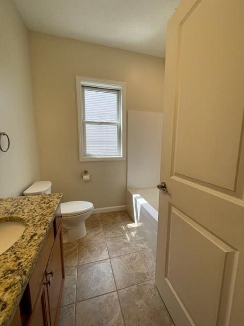 bathroom with vanity, a tub, tile patterned floors, and toilet