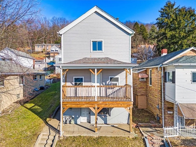 back of property with a lawn and a patio area