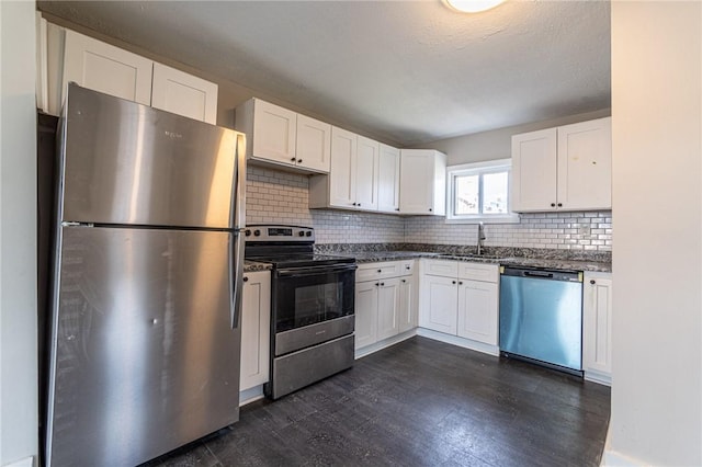 kitchen featuring sink, dark wood-type flooring, appliances with stainless steel finishes, white cabinets, and decorative backsplash