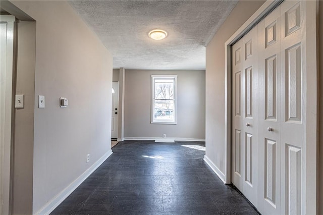 hallway featuring dark wood-type flooring and a textured ceiling