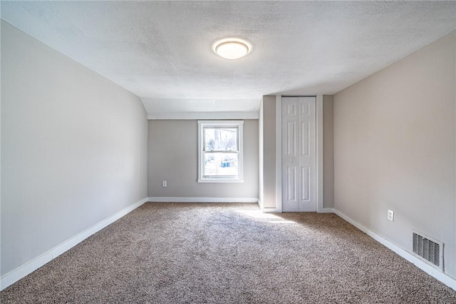 carpeted spare room featuring a textured ceiling