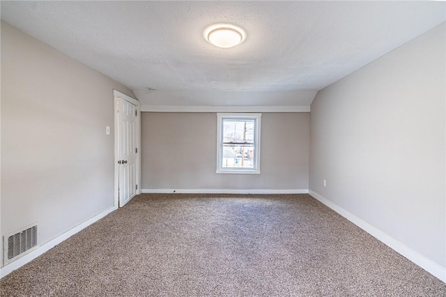 spare room with a textured ceiling and carpet flooring