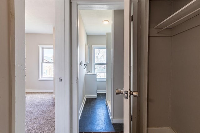 hall with dark colored carpet