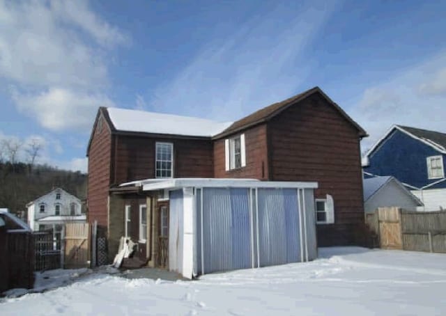 view of snow covered rear of property