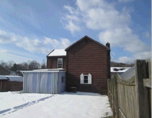 view of snow covered back of property