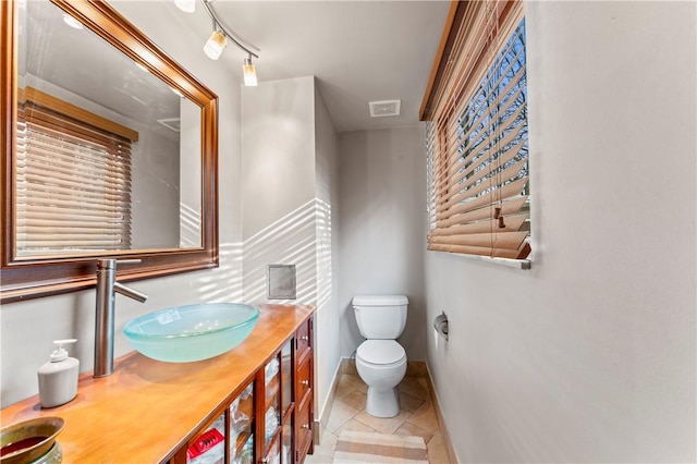 bathroom featuring vanity, tile patterned floors, and toilet