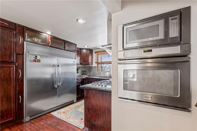 kitchen featuring dark wood-type flooring and built in appliances