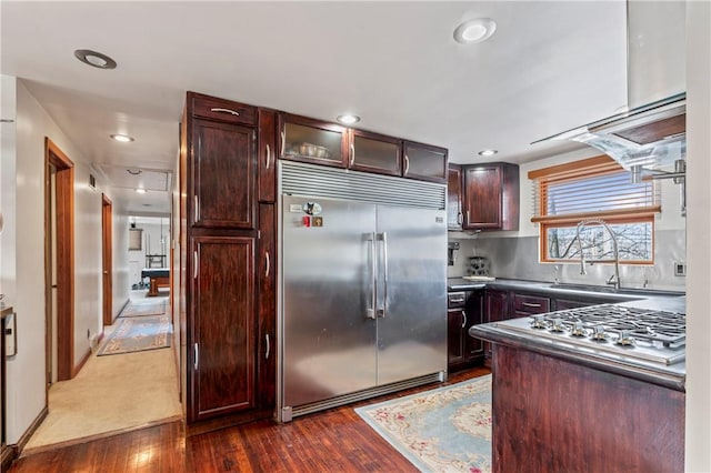 kitchen with built in refrigerator, dark hardwood / wood-style flooring, and sink