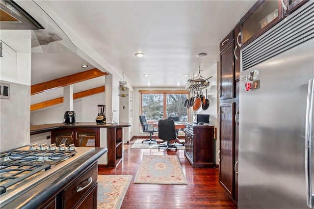 kitchen featuring dark wood-type flooring, lofted ceiling, appliances with stainless steel finishes, and hanging light fixtures