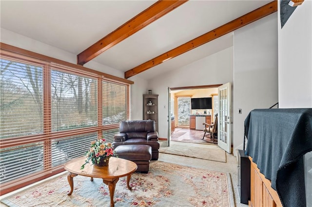 carpeted living room with vaulted ceiling with beams and a wealth of natural light