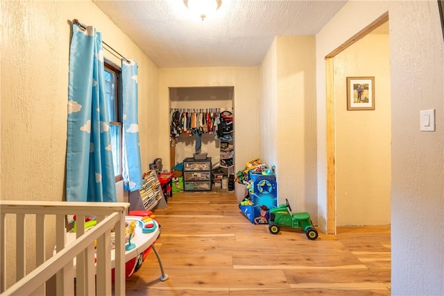 hallway with hardwood / wood-style flooring and a textured ceiling