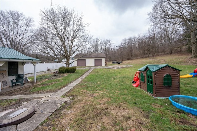 view of yard featuring a garage and an outdoor structure