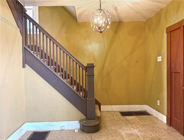 tiled foyer featuring a notable chandelier and a high ceiling