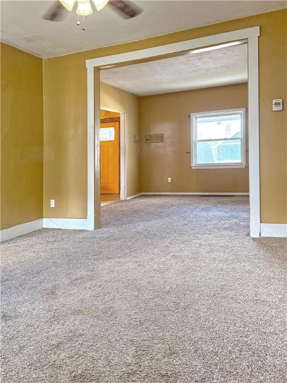 carpeted spare room with ceiling fan