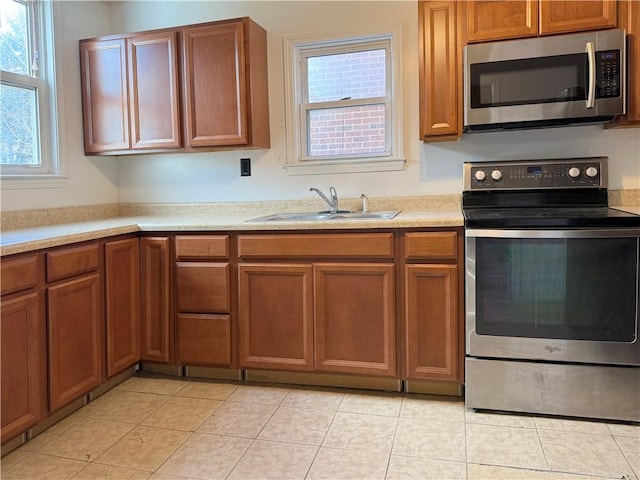 kitchen featuring light tile patterned flooring, appliances with stainless steel finishes, and sink