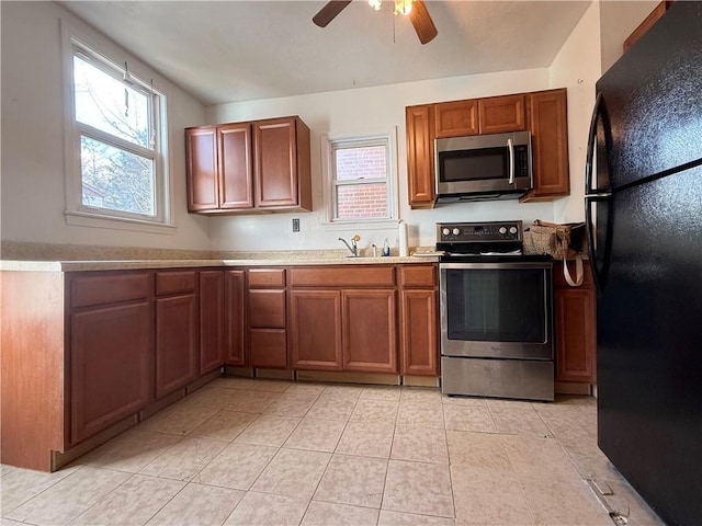 kitchen with light tile patterned flooring, ceiling fan, stainless steel appliances, and sink