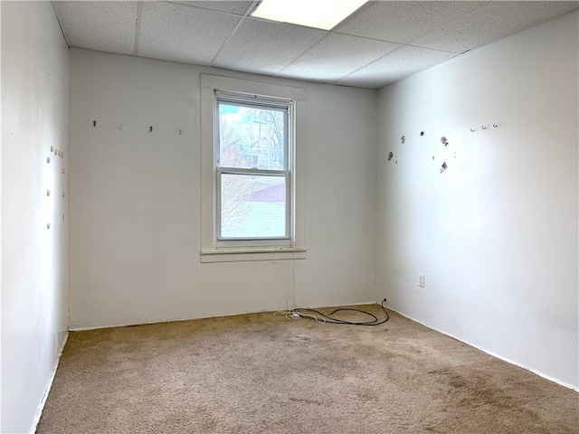 carpeted empty room featuring a paneled ceiling