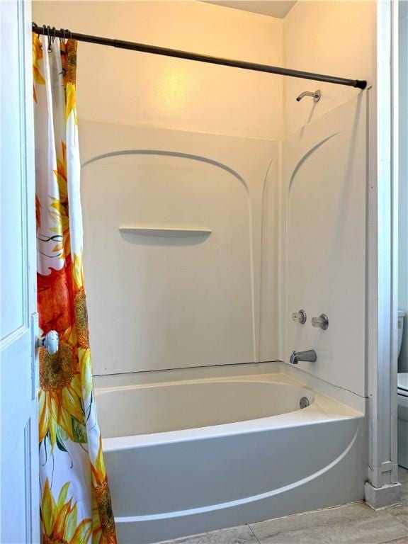 bathroom with shower / bathtub combination with curtain and toilet