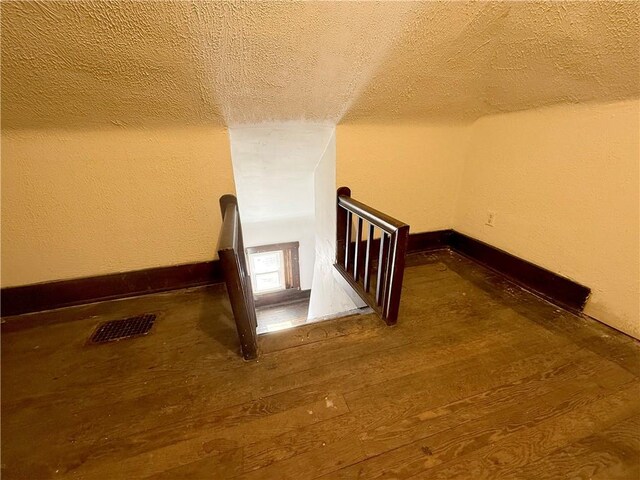 stairs featuring hardwood / wood-style floors and a textured ceiling