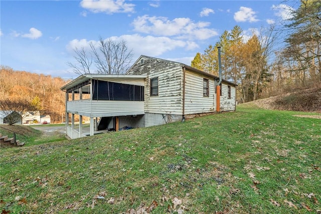 view of home's exterior featuring a sunroom and a yard