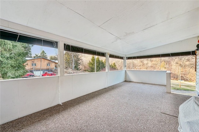 unfurnished sunroom featuring lofted ceiling and a wealth of natural light