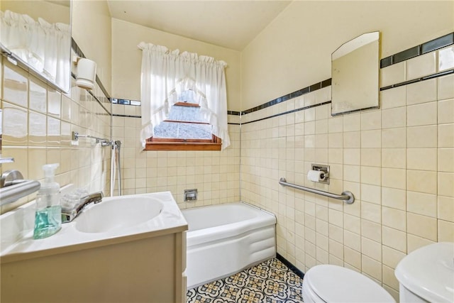 bathroom with toilet, tile walls, vanity, a tub, and tile patterned flooring