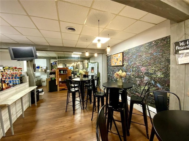 dining space featuring a paneled ceiling and hardwood / wood-style floors