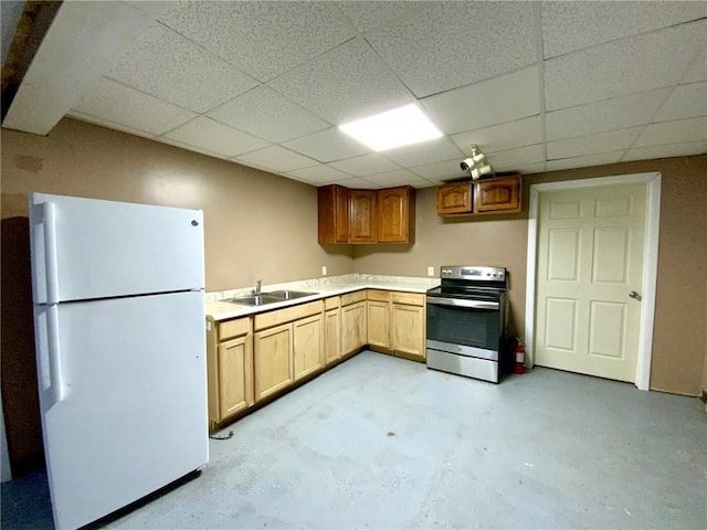 kitchen with stainless steel electric stove, sink, white fridge, and a drop ceiling