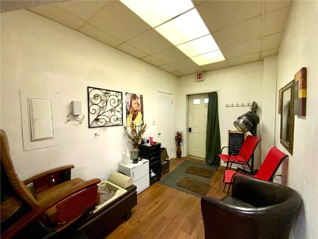 interior space with hardwood / wood-style flooring, a drop ceiling, and electric panel