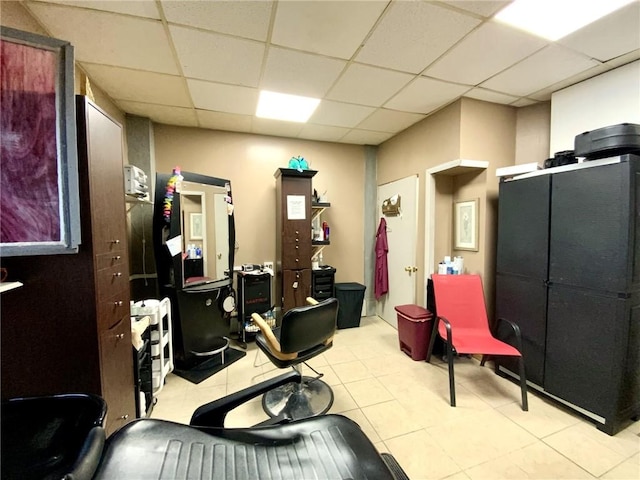 exercise area with light tile patterned flooring and a drop ceiling